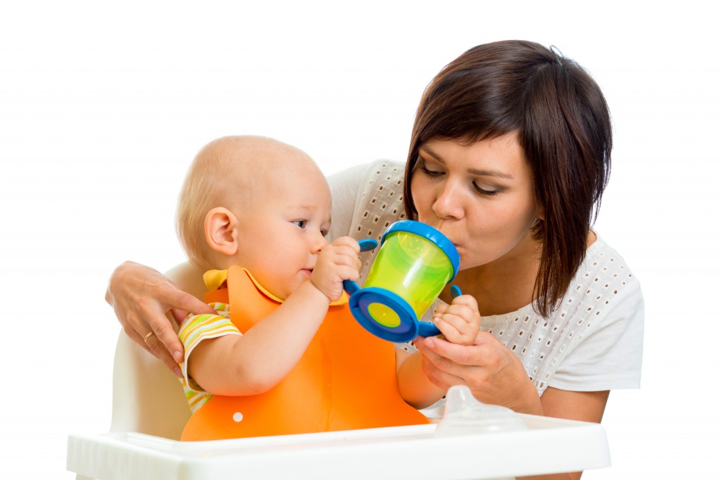 woman and baby drinking from sippy cup